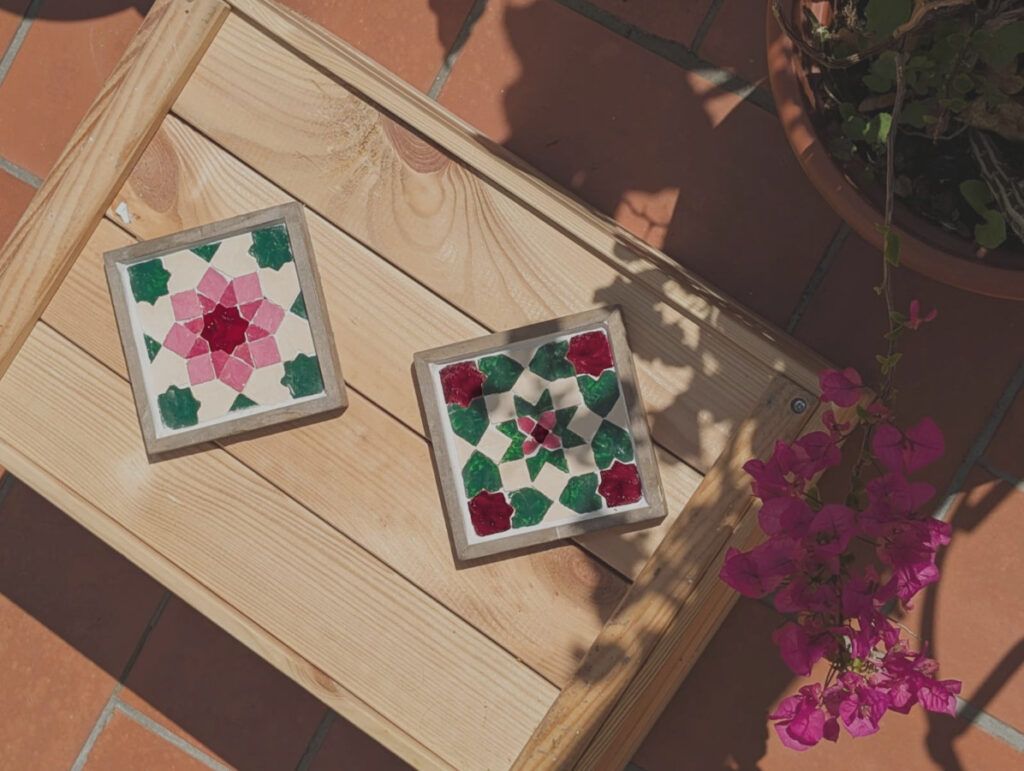 Twee Florals-onderzetters op een houten tafel buiten met bougainville